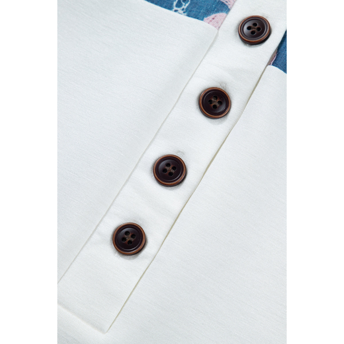 Blusa bianca a maniche corte con inserti floreali — dettaglio dei bottoni
