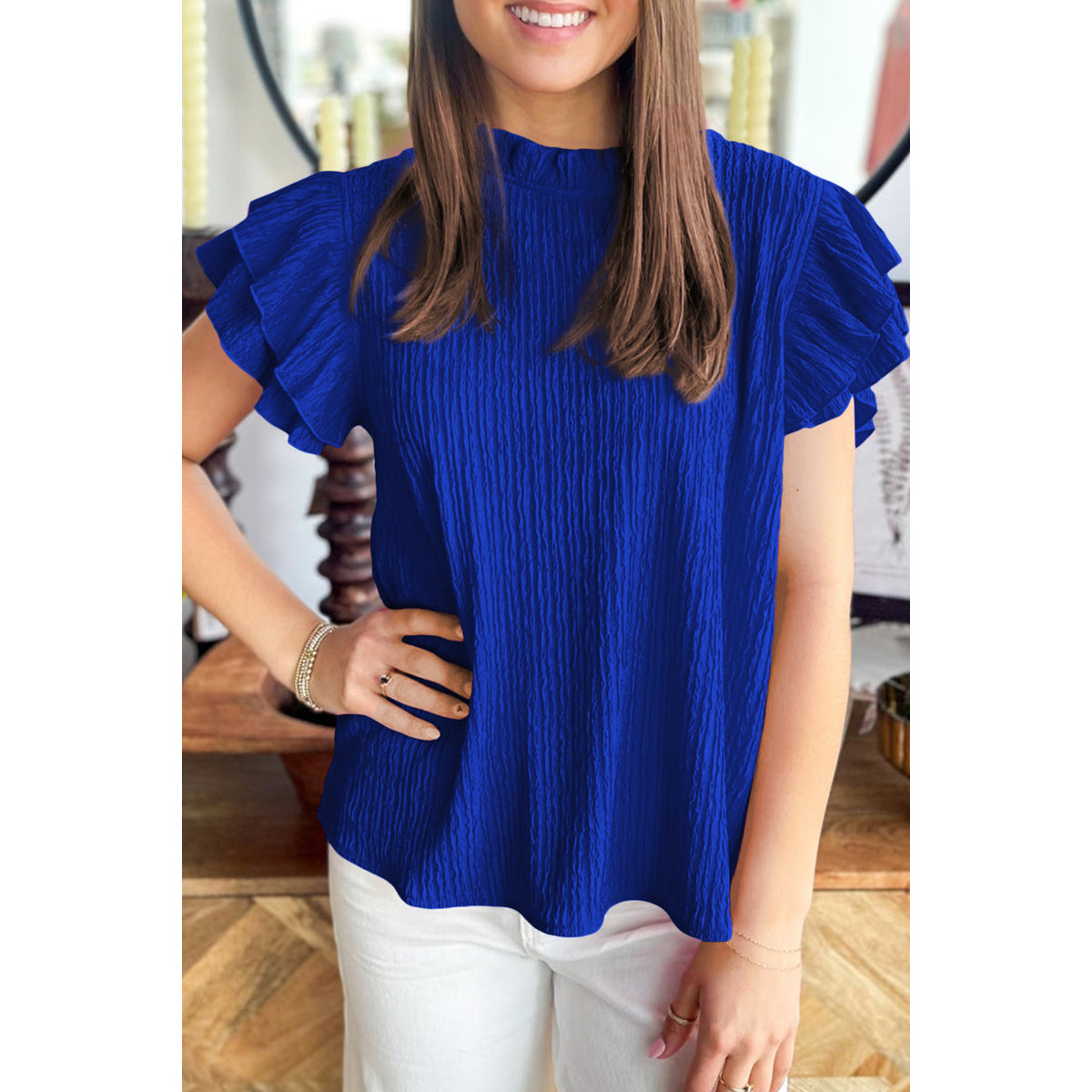 Blusa blu scuro in tessuto lavorato con maniche a volant — vestibilità sul modello