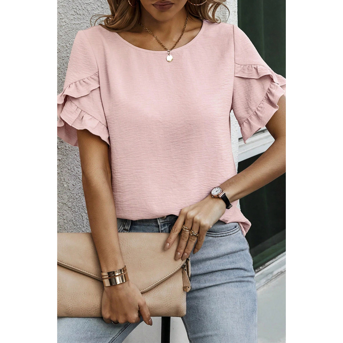 Blusa rosa chiaro con maniche a volant — maniche e vestibilità sul modello