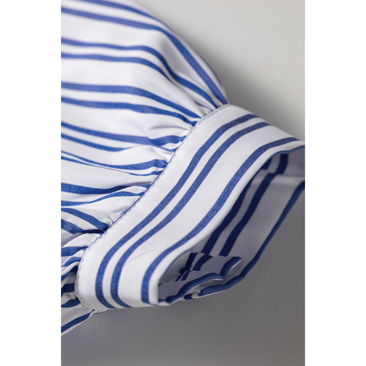 Camicia a righe blu con ricamo floreale — dettaglio del polsino