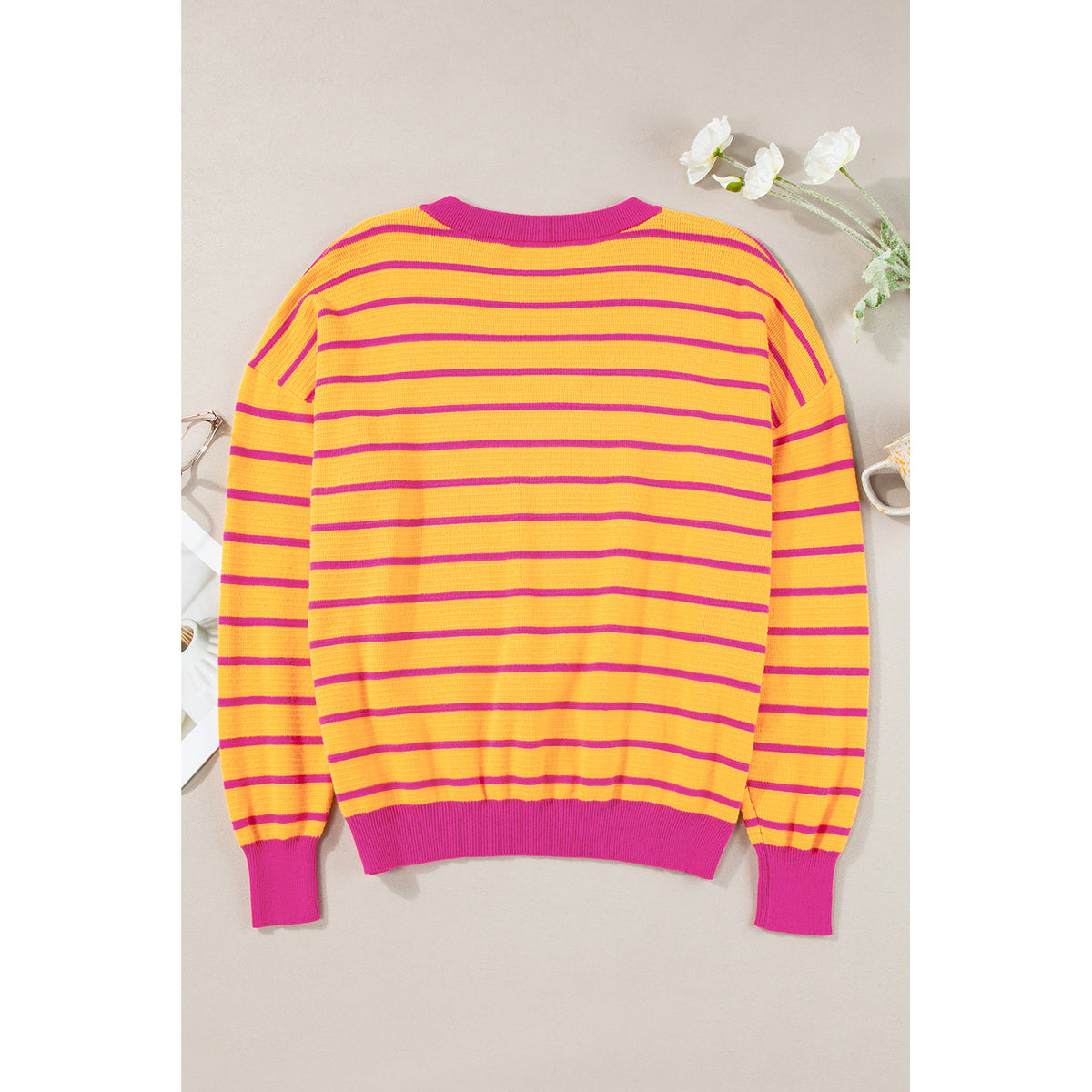 Maglione a righe arancioni e rosa con spalle scese — vista frontale del capo disteso