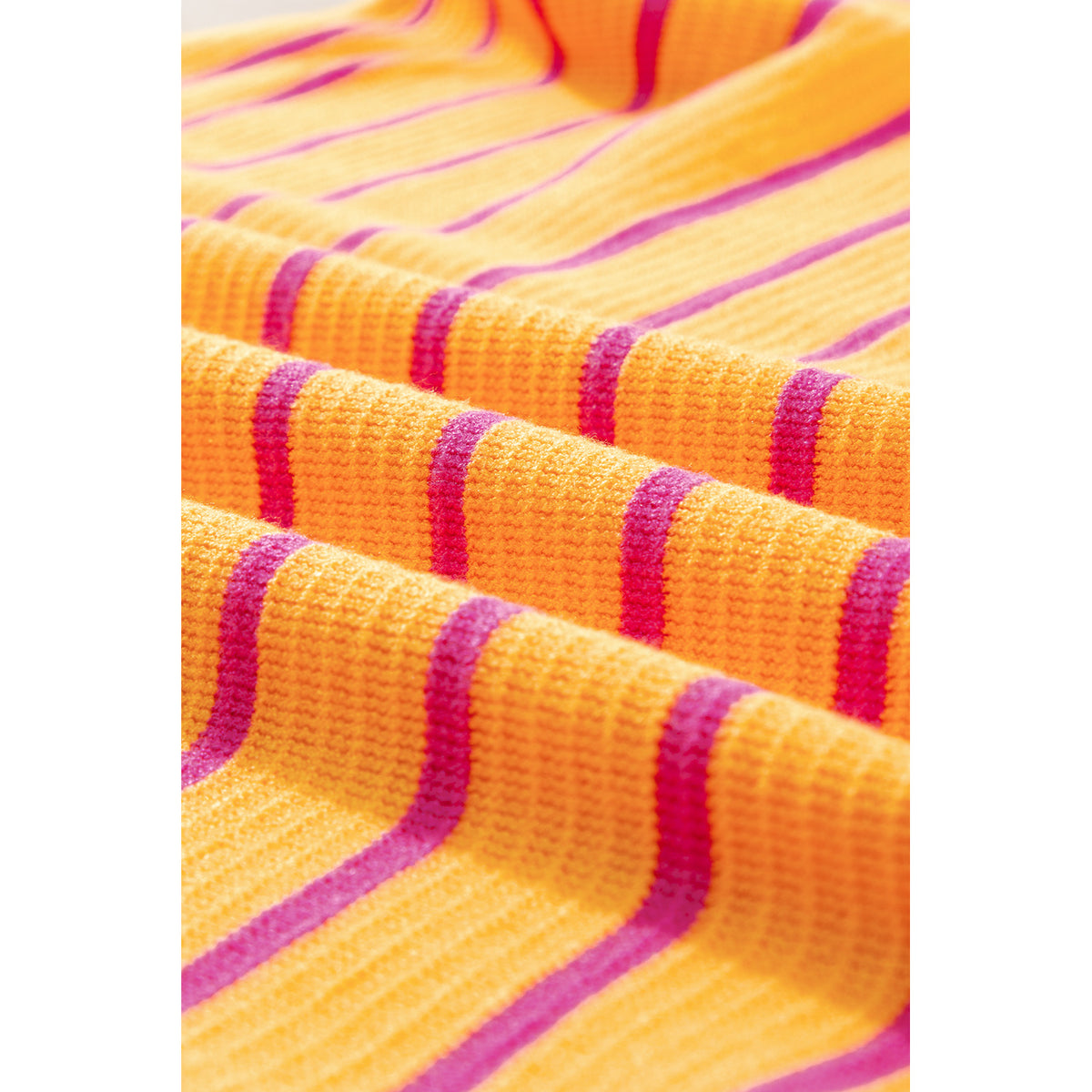 Maglione a righe arancioni e rosa con spalle scese — dettaglio della maglia a righe