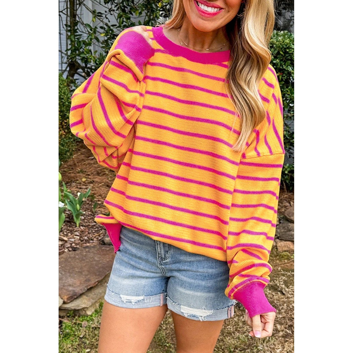 Maglione a righe arancioni e rosa con spalle scese — vestibilità sul modello