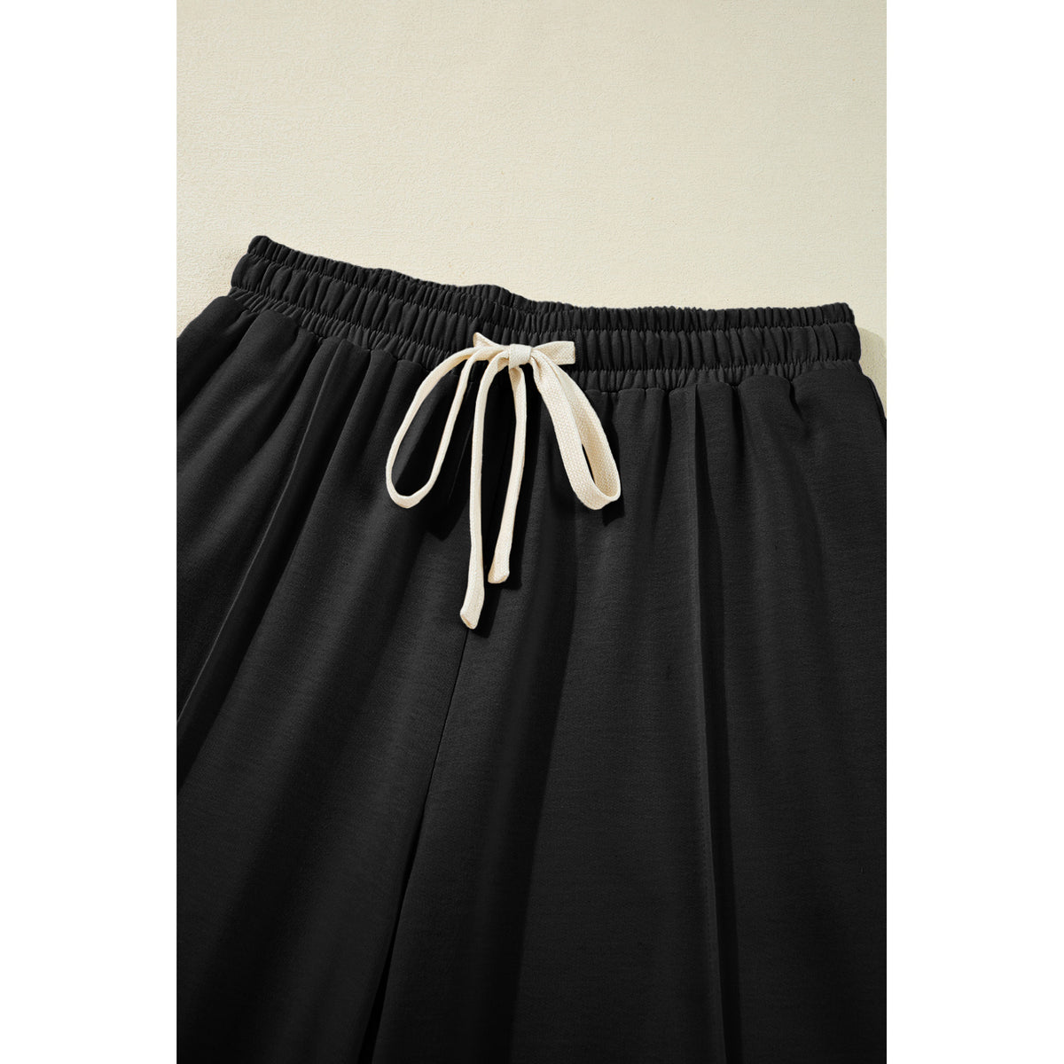 Pantaloni cargo neri con coulisse e cuciture frontali — dettaglio della vita con coulisse