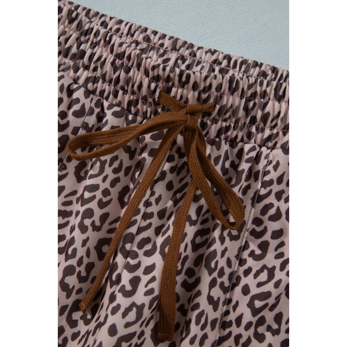 Pantaloni kaki leopardati alla caviglia con coulisse — dettaglio della vita con coulisse